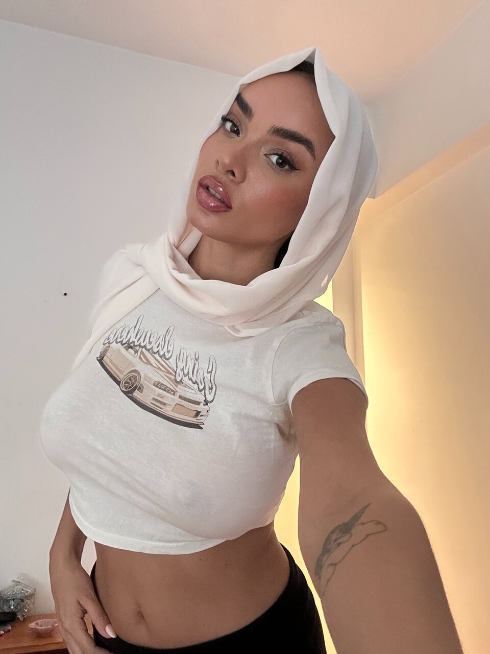 فتاة بمفردها تشكل قلباً بأصابعها وترتدي كمامة وجه